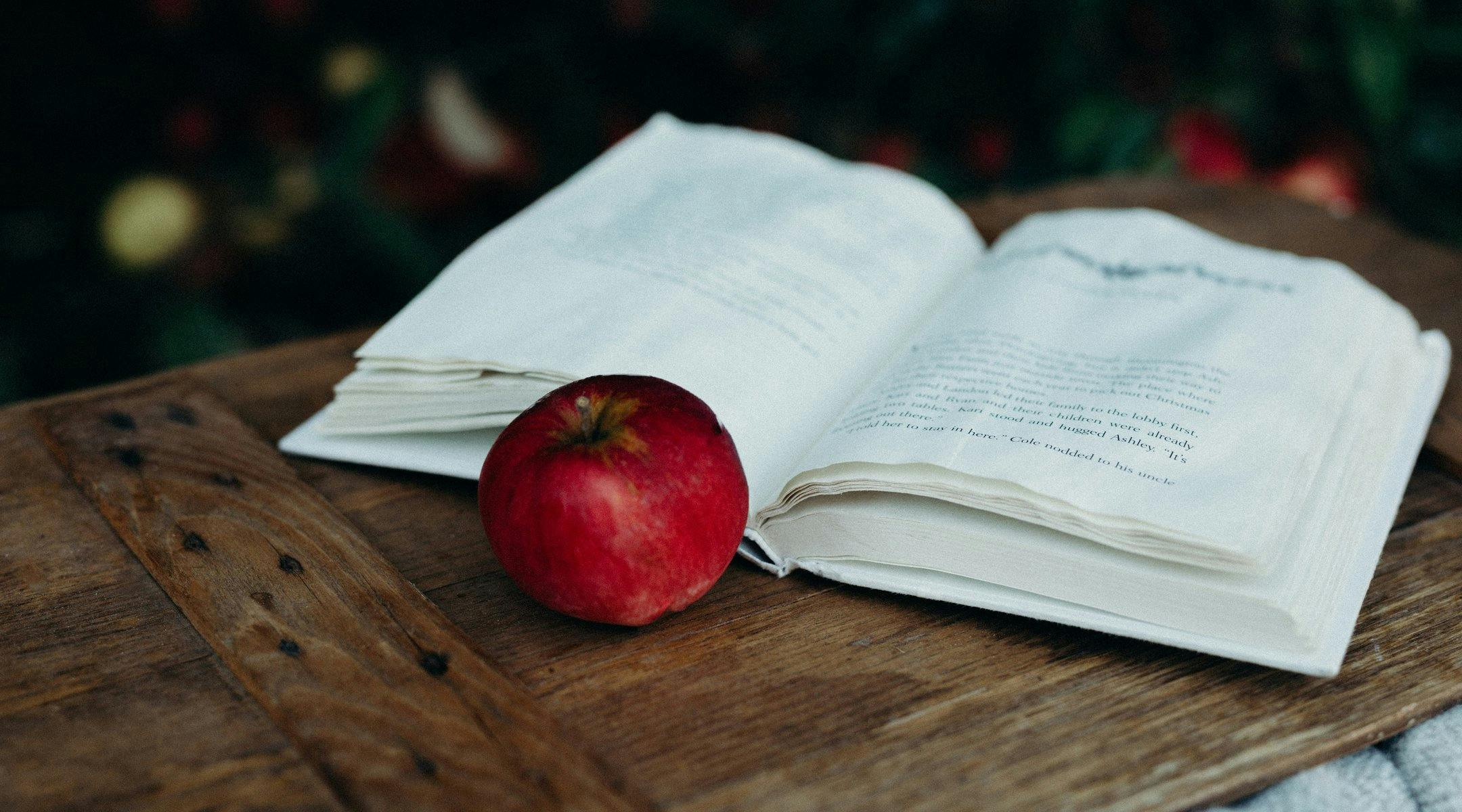 En åpen bok og et eple.